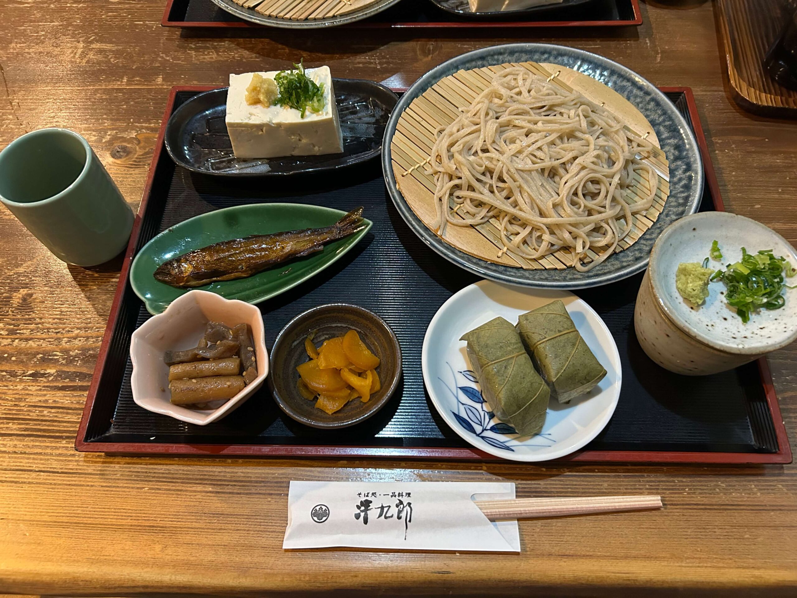 手打ちそば処 清九郎の清九郎セット。ざるそば、柿の葉寿司（鮭）、名水豆腐、川魚の甘露煮、小鉢、漬物が並ぶ